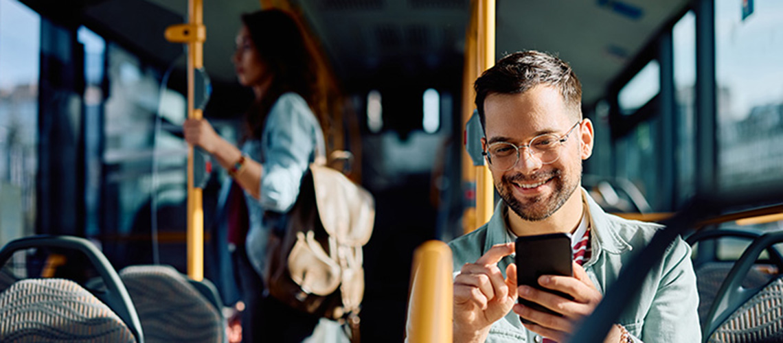 Mann mit Handy in der Hand im Bus