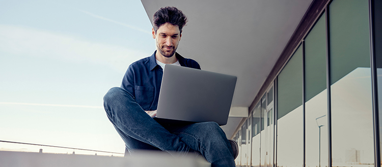 Mann sitzt am Laptop