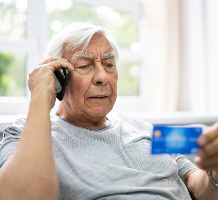 Mann am Telefon mit Debitkarte